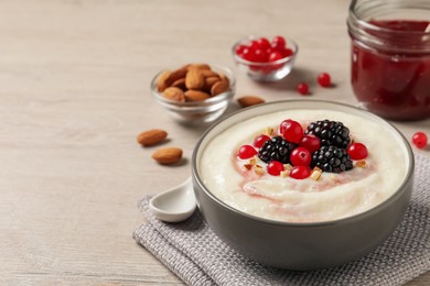 Delicious semolina pudding with berries on wooden table, space for text