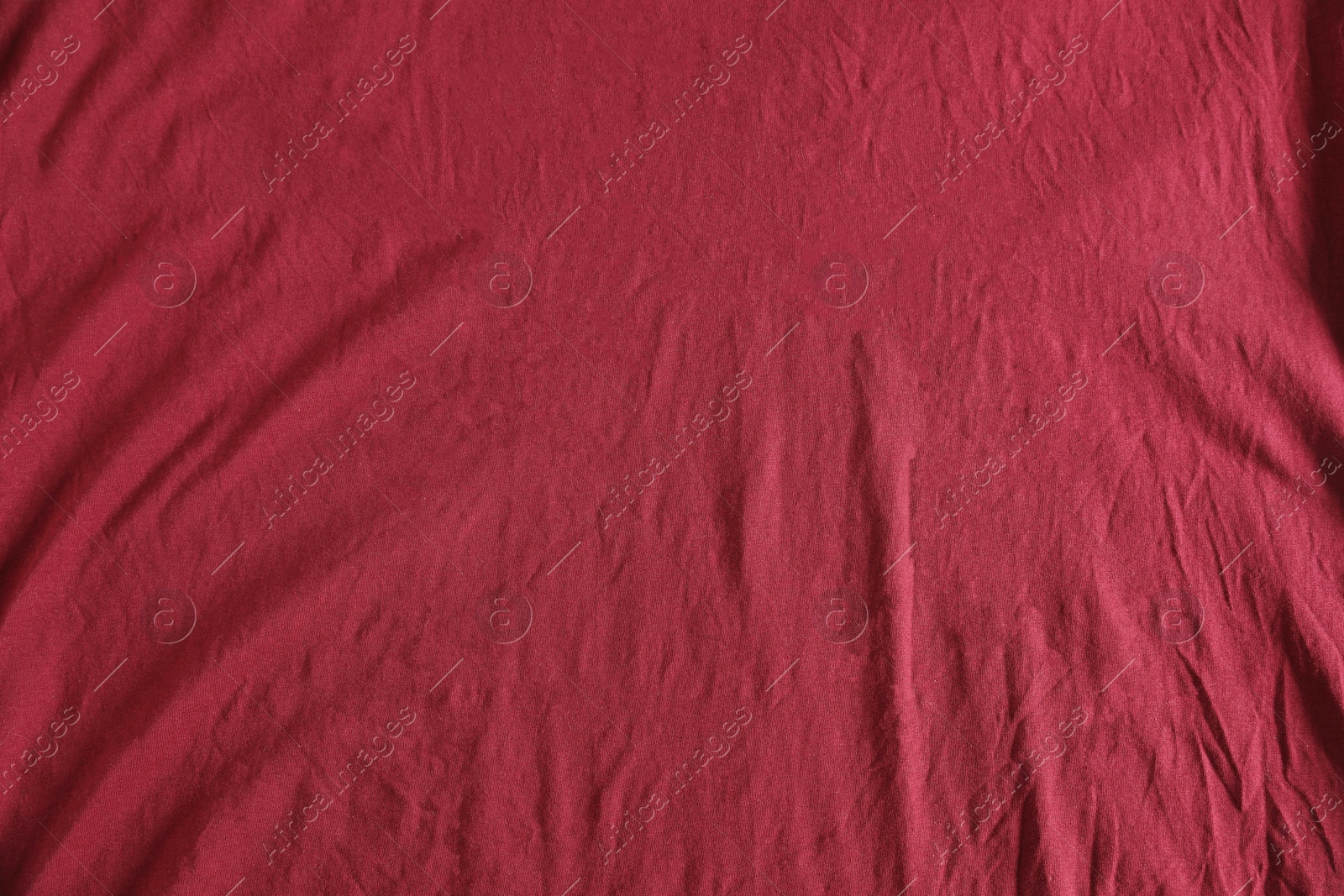 Photo of Crumpled dark red fabric as background, top view