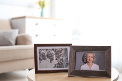 Photo of Portraits in stylish frames on table indoors