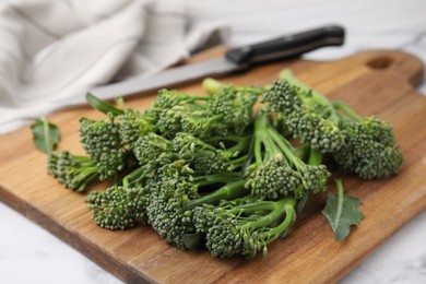 Photo of Fresh raw broccolini on wooden board, closeup. Healthy food