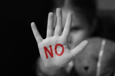Image of Child abuse. Girl making stop gesture, black and white effect. No written on her hand