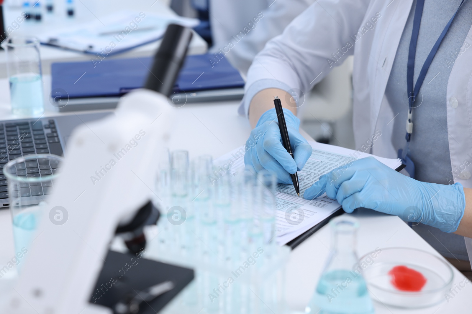 Photo of Laboratory worker working at white table, closeup