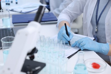 Laboratory worker working at white table, closeup