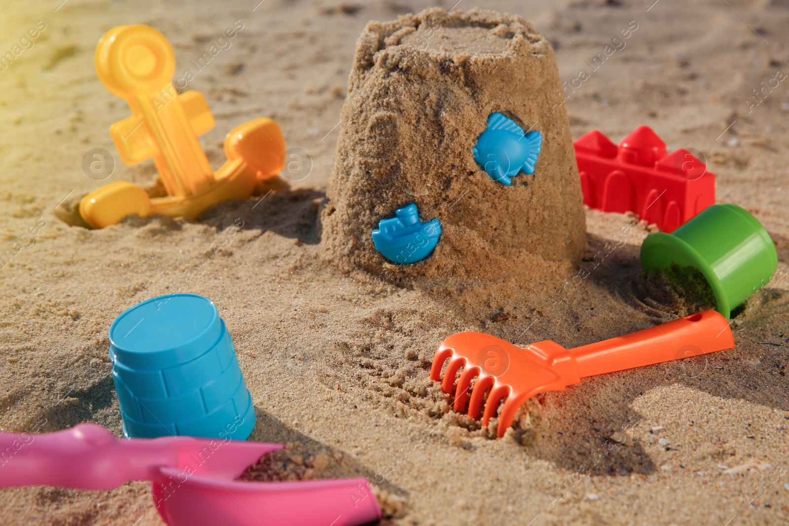 Photo of Set of plastic beach toys on sand. Outdoor play