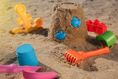 Photo of Set of plastic beach toys on sand. Outdoor play