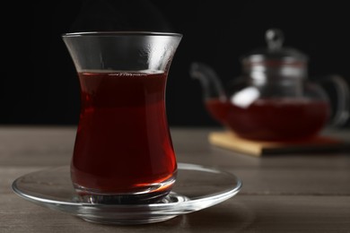 Glass of traditional Turkish tea on wooden table, space for text