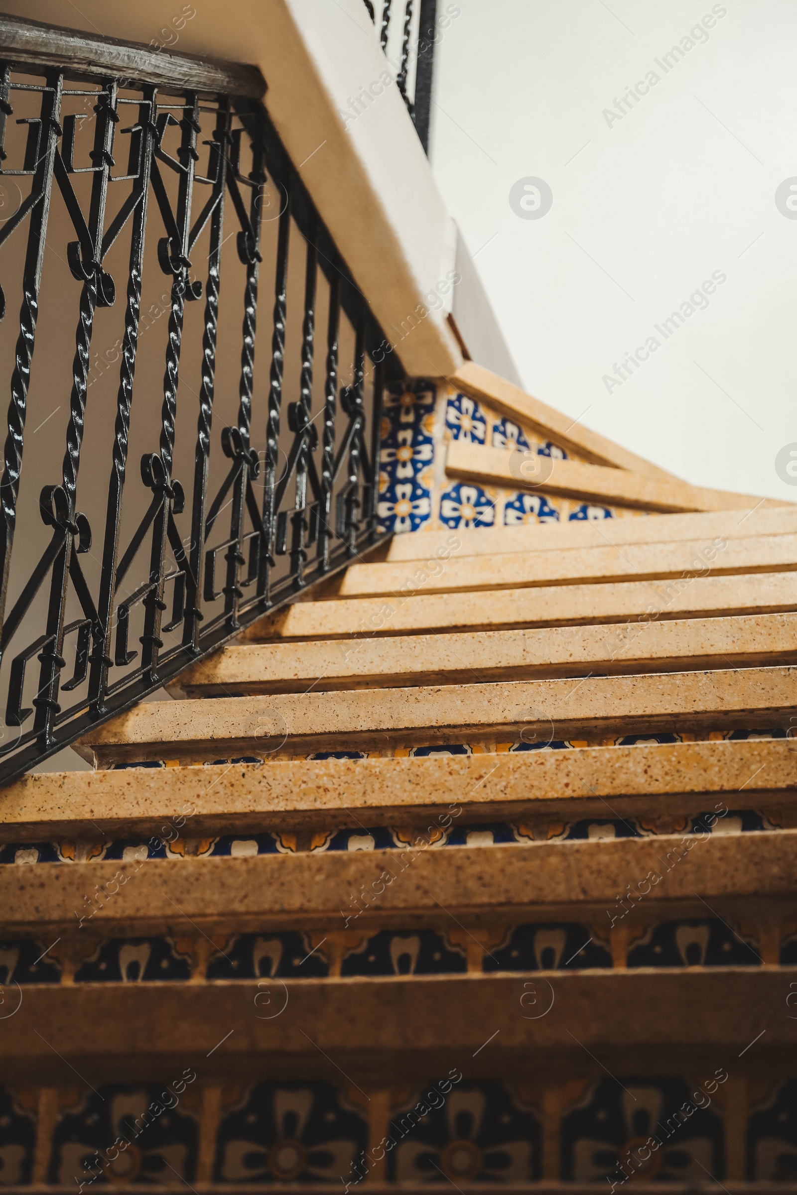 Photo of Stairs and black metal railing indoors, low angle view. Interior design