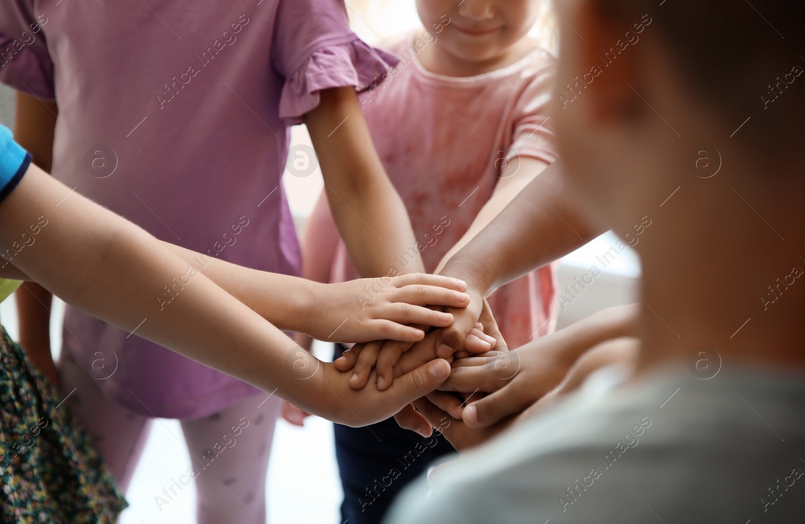 Photo of Little children putting their hands together, closeup. Unity concept