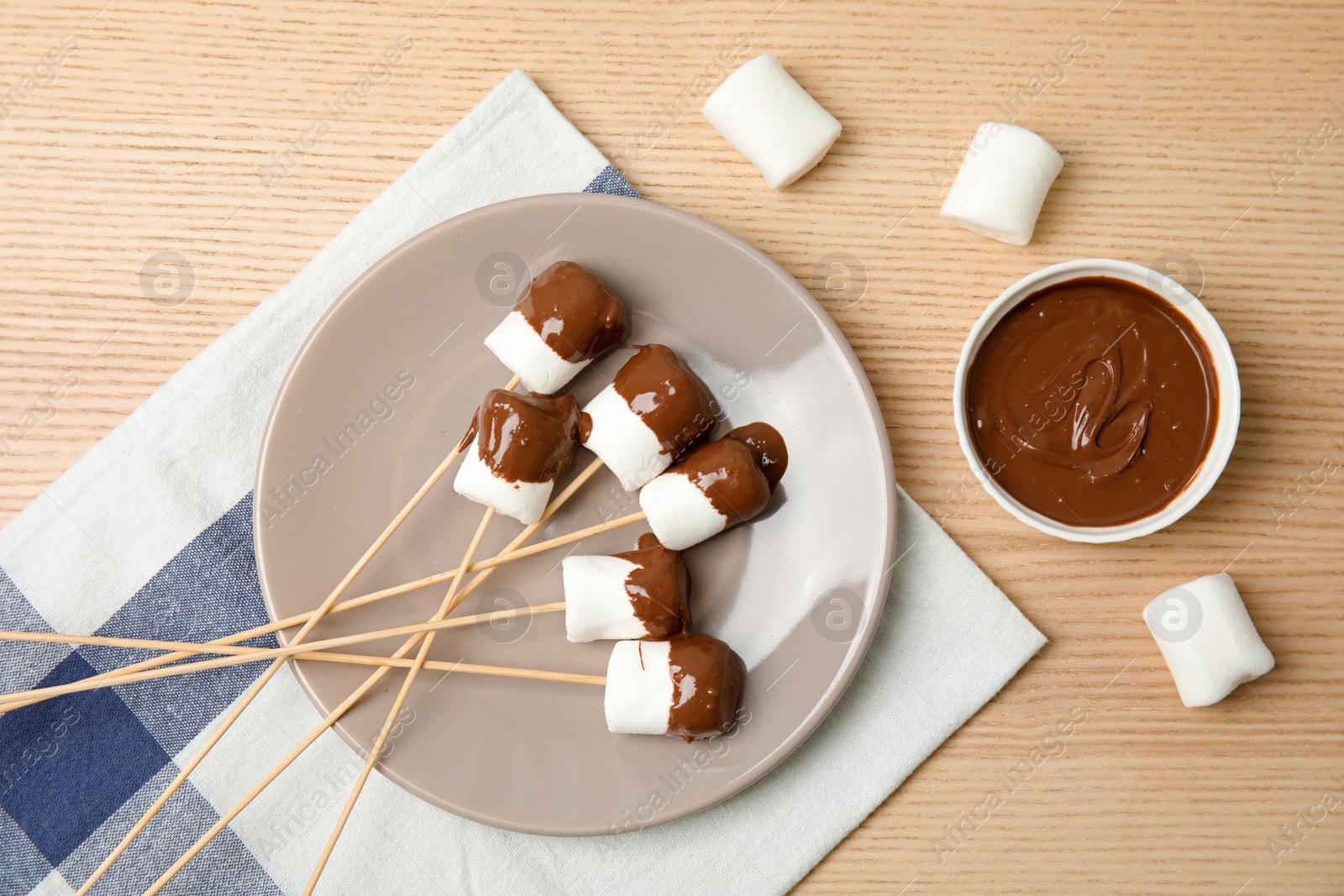 Photo of Flat lay composition with chocolate fondue in bowl and marshmallows on wooden background