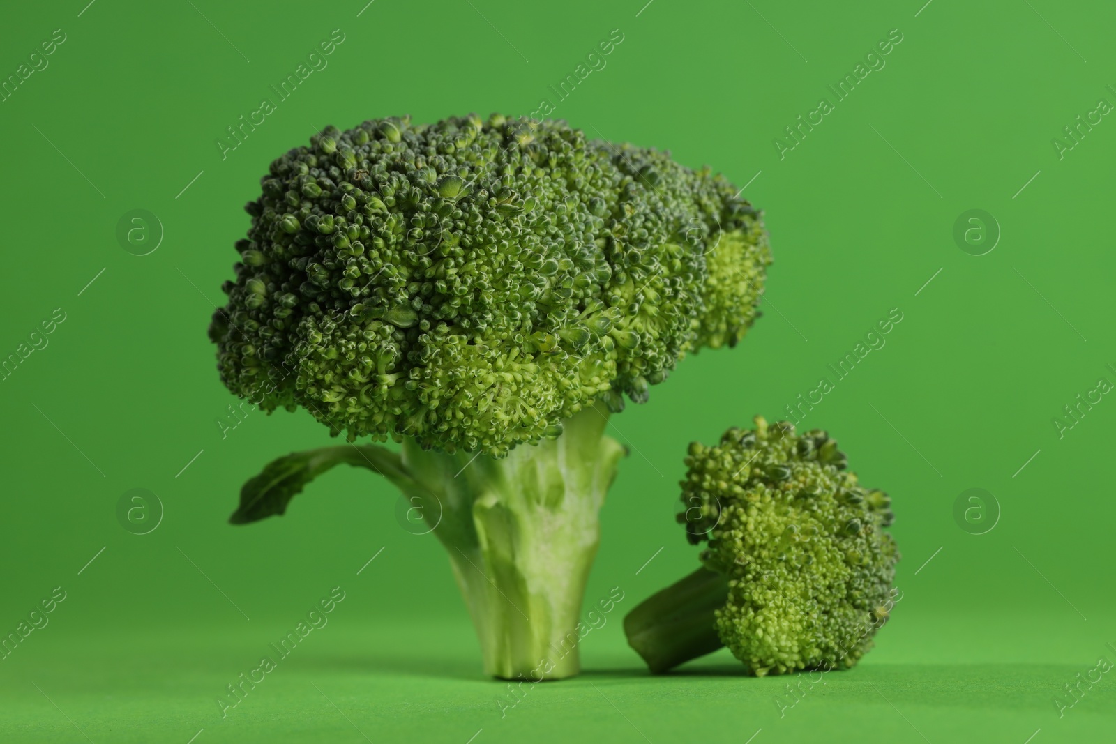 Photo of Fresh raw broccoli on light green background