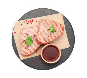 Photo of Delicious tuna steaks with sauce, parsley and spices on white background, top view