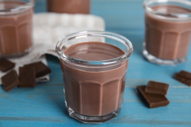 Photo of Delicious chocolate milk on light blue wooden table