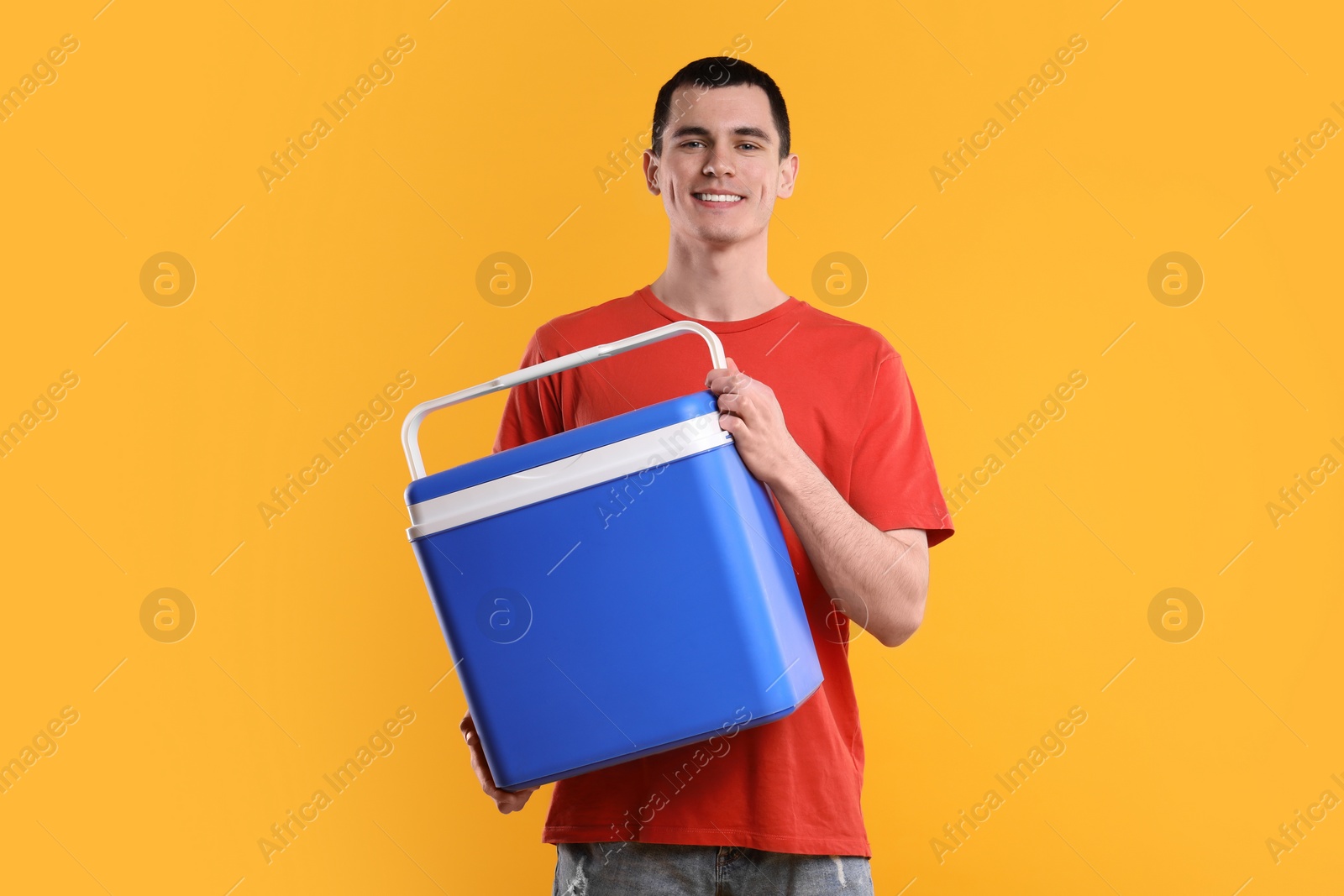 Photo of Man with blue cool box on orange background