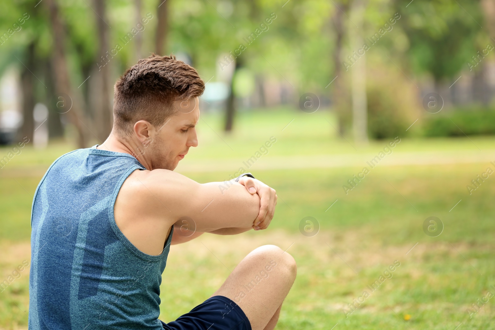 Photo of Man in sportswear suffering from elbow pain outdoors