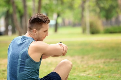 Photo of Man in sportswear suffering from elbow pain outdoors