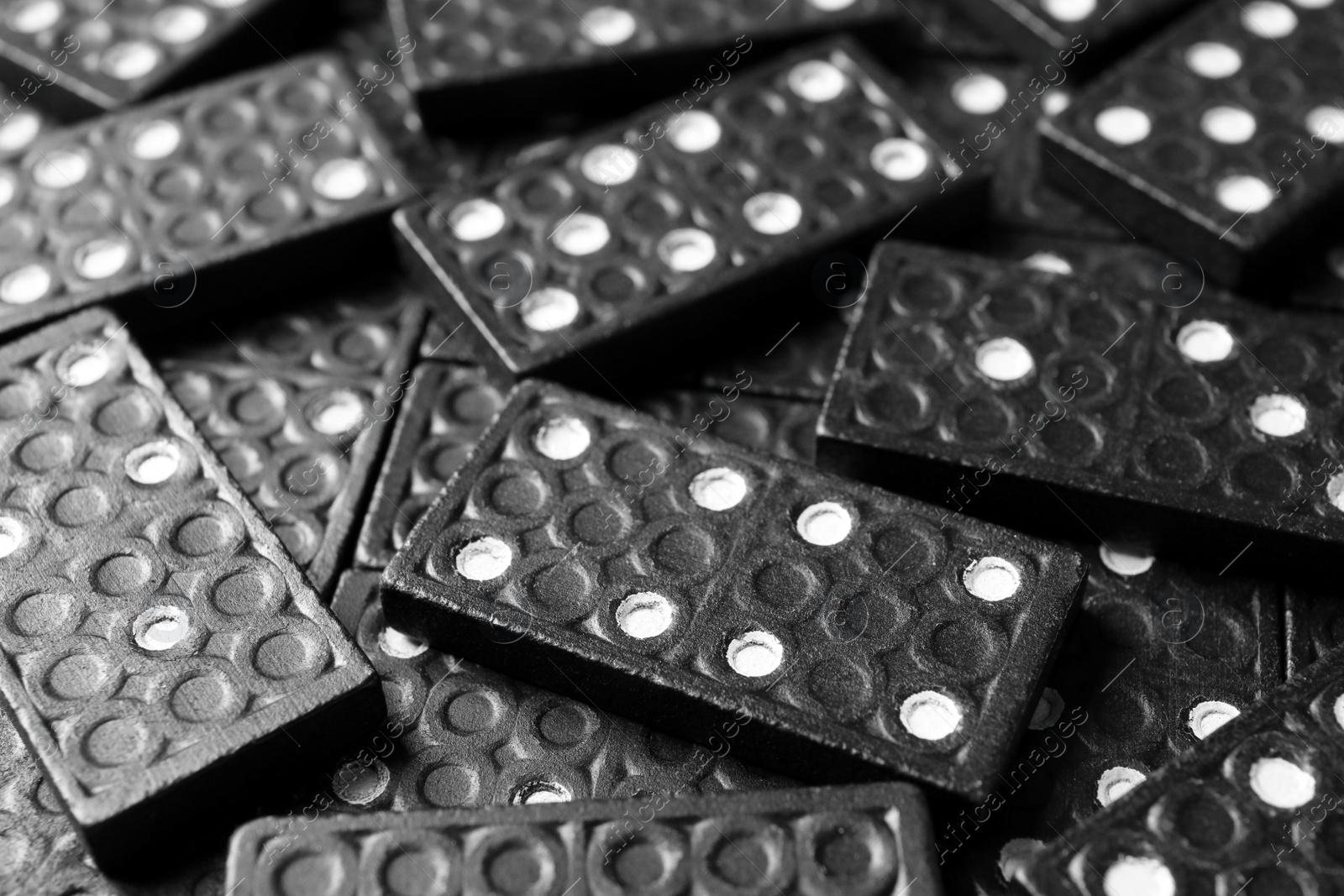 Photo of Set of black domino tiles as background, closeup