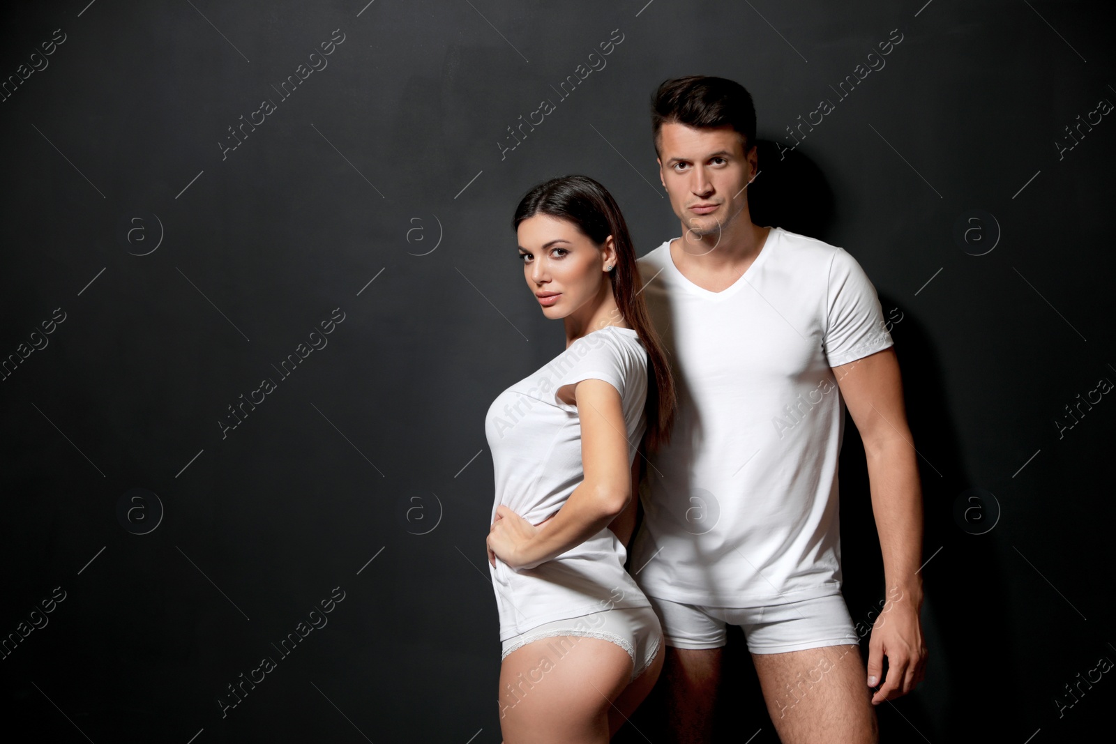 Photo of Young couple wearing underwear on black background