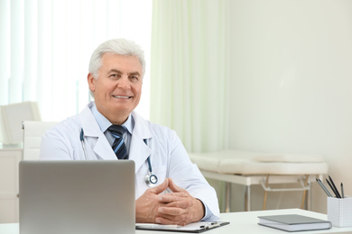 Photo of Portrait of senior doctor in white coat at workplace