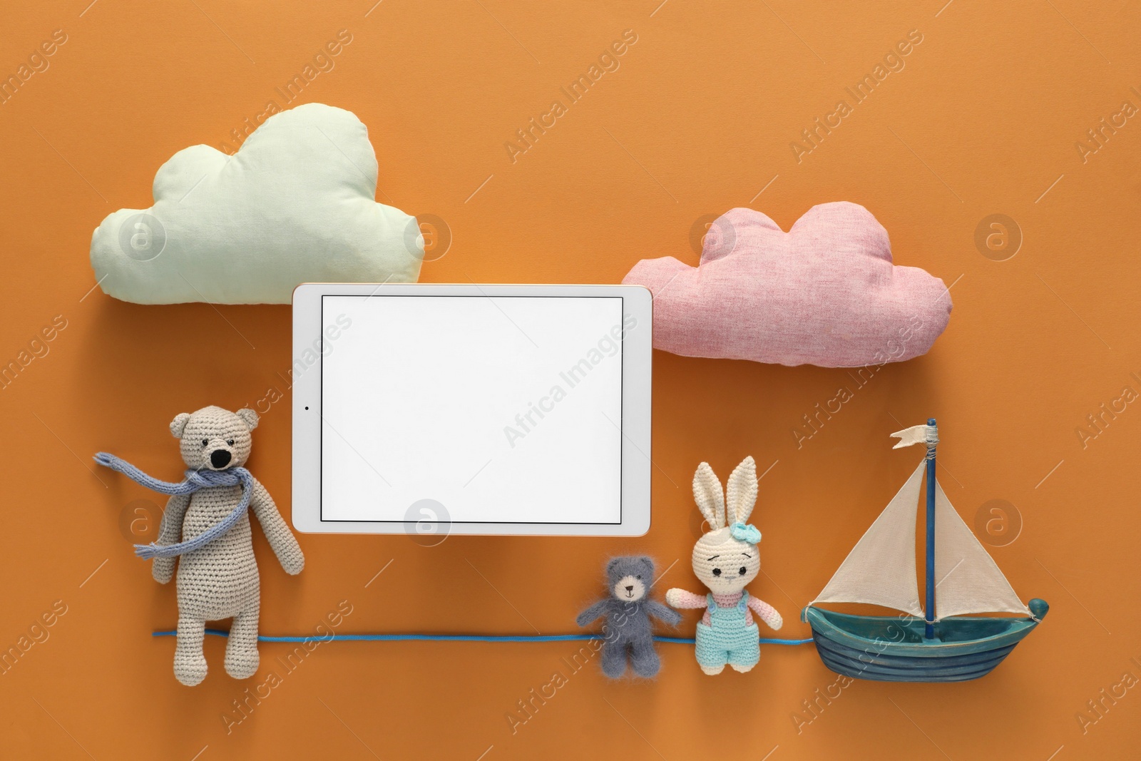 Photo of Modern tablet and toys on brown background, flat lay. Space for text