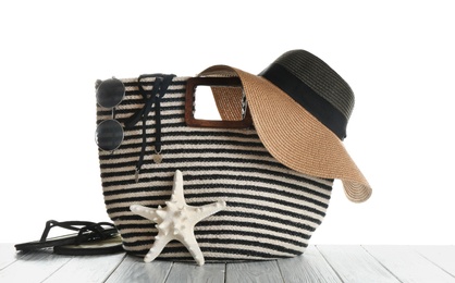 Set of beach accessories on wooden table, white background