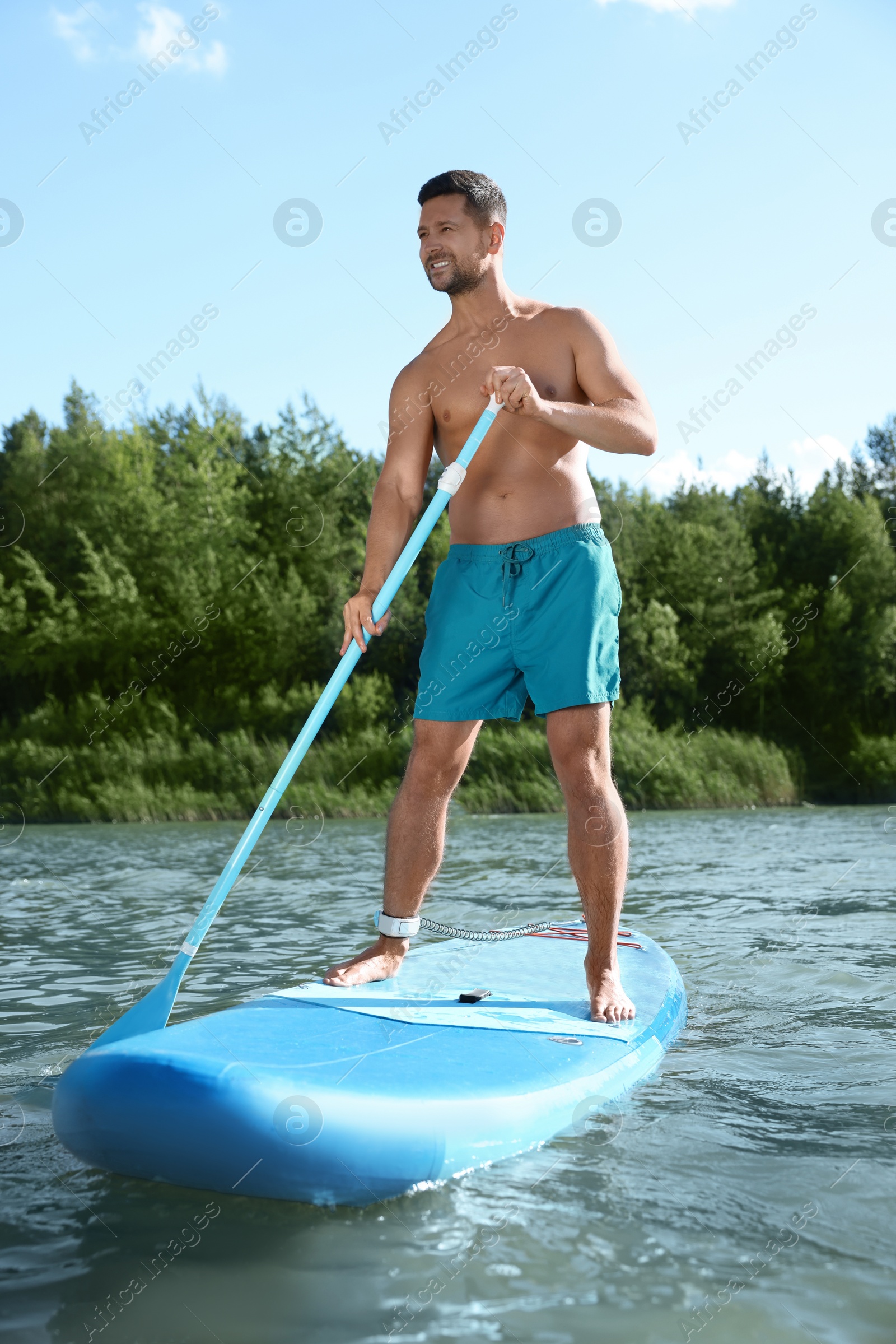 Photo of Man paddle boarding on SUP board in river