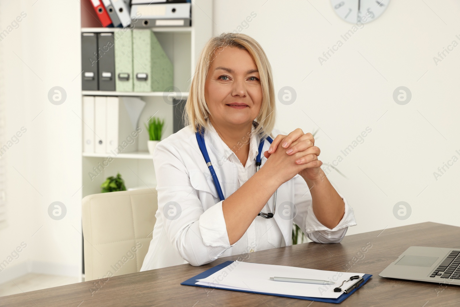 Photo of Doctor sitting at wooden table in clinic