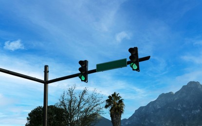 View of traffic lights, road sign and beautiful mountains