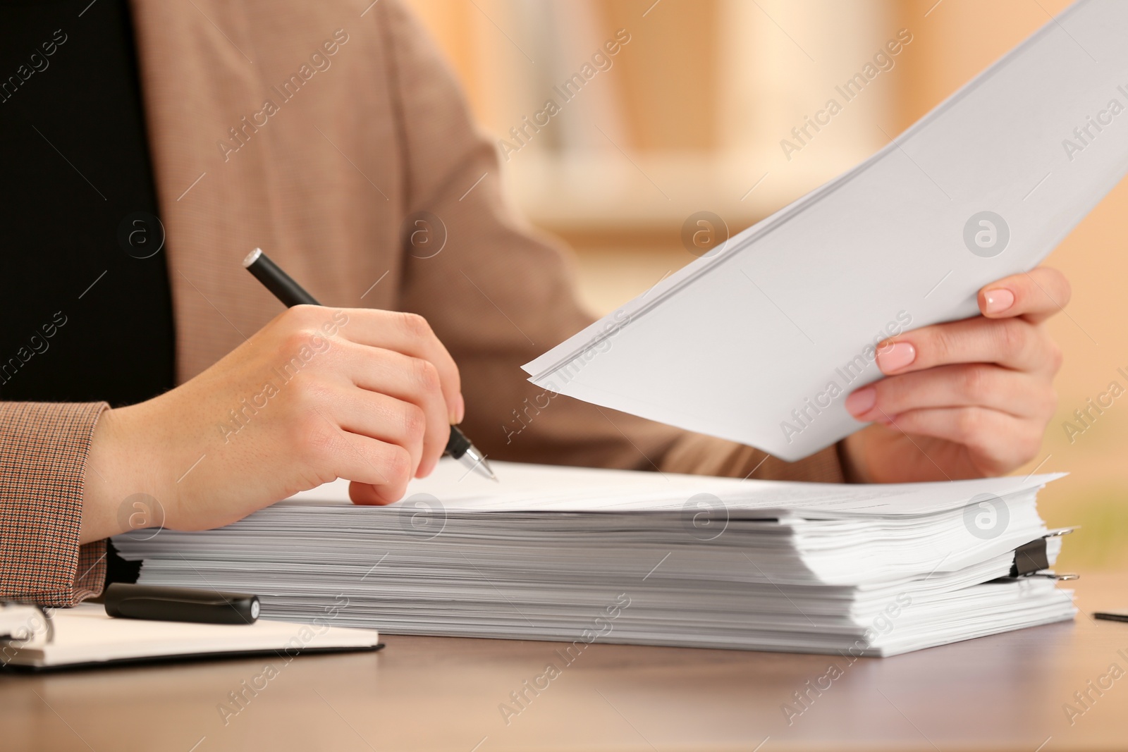 Photo of Woman signing documents at table in office, closeup