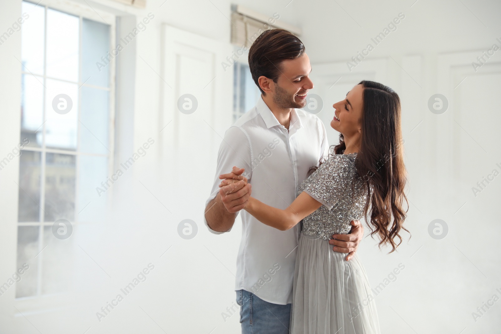 Photo of Lovely young couple dancing together in ballroom. Space for text