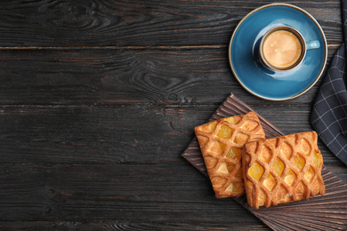 Delicious pastries and coffee on black wooden table, flat lay. Space for text