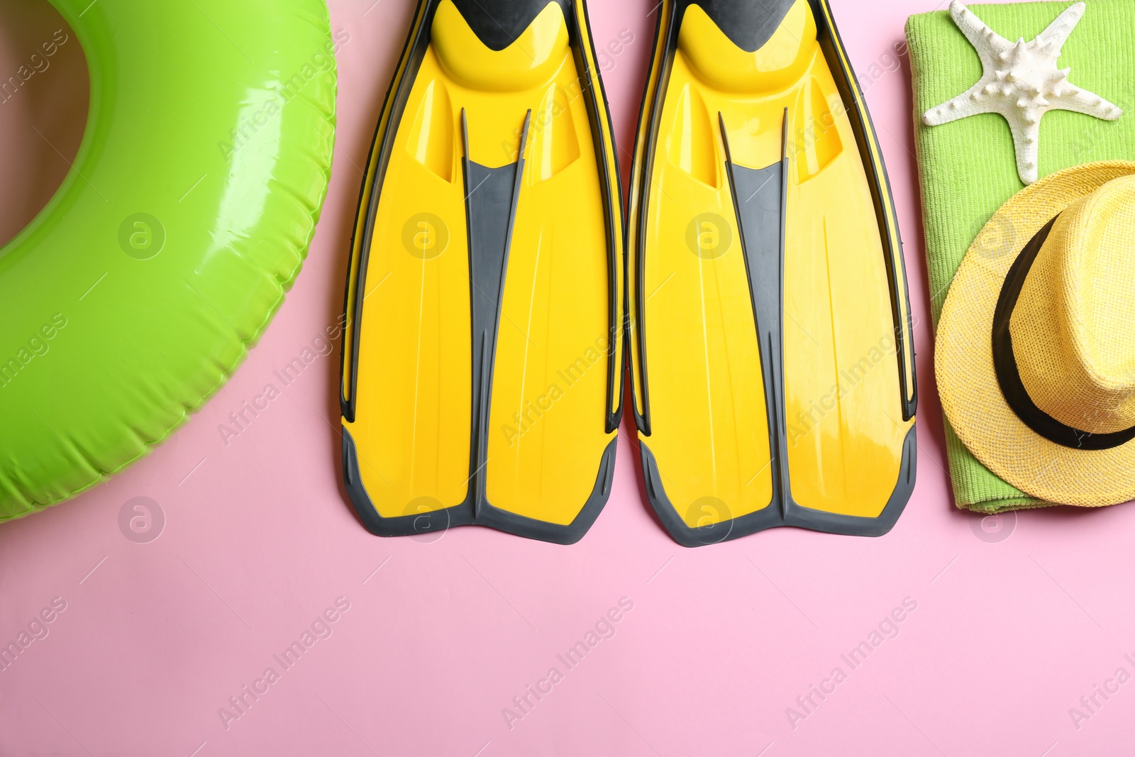 Photo of Flat lay composition with beach accessories on pink background