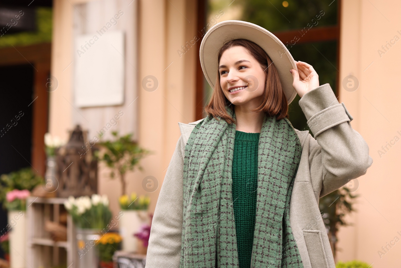 Photo of Beautiful woman in warm scarf and hat outdoors