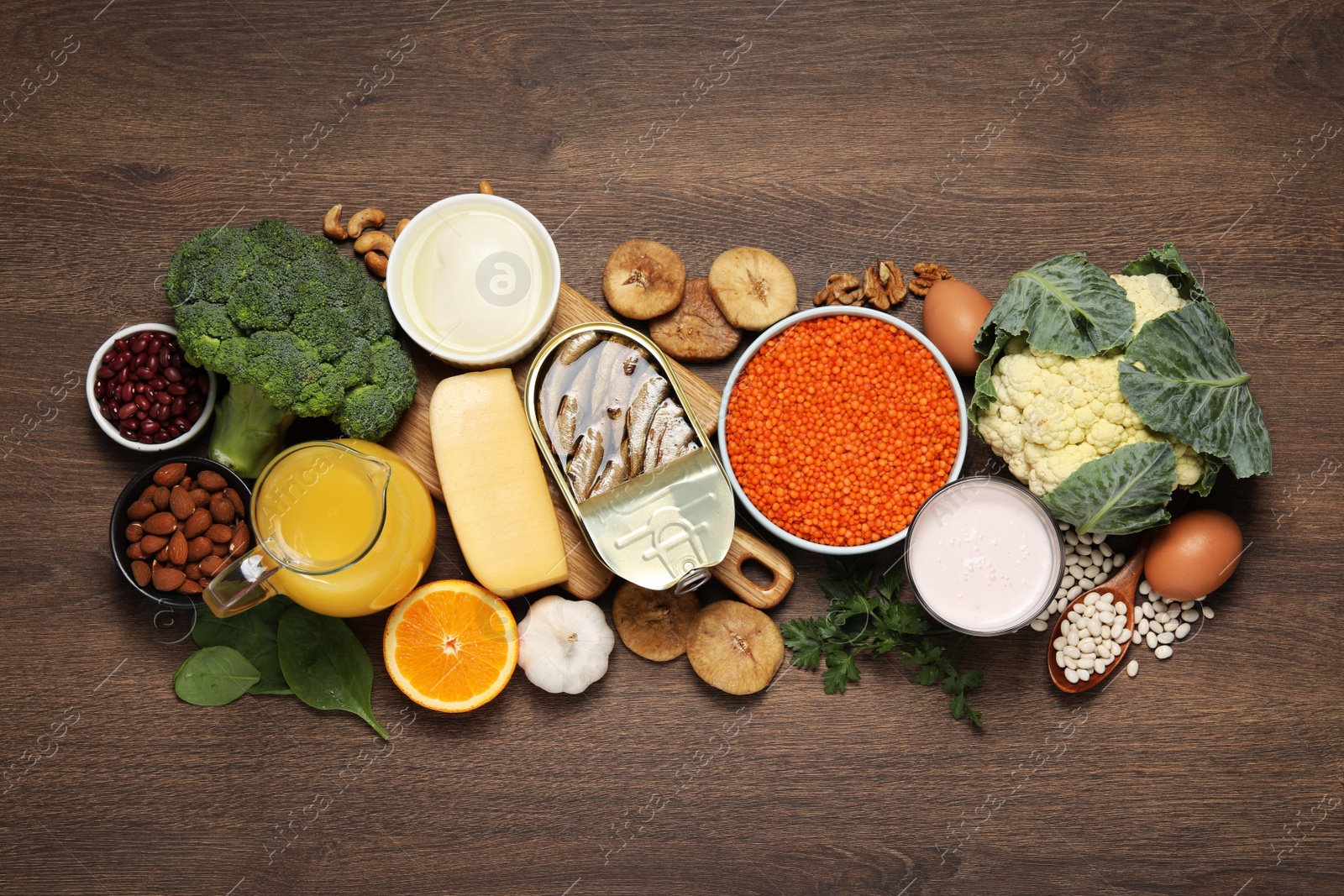 Photo of Set of natural food high in calcium on wooden table, flat lay