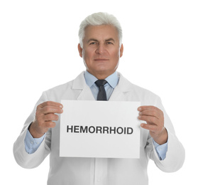 Photo of Doctor holding sign with word HEMORRHOID on white background