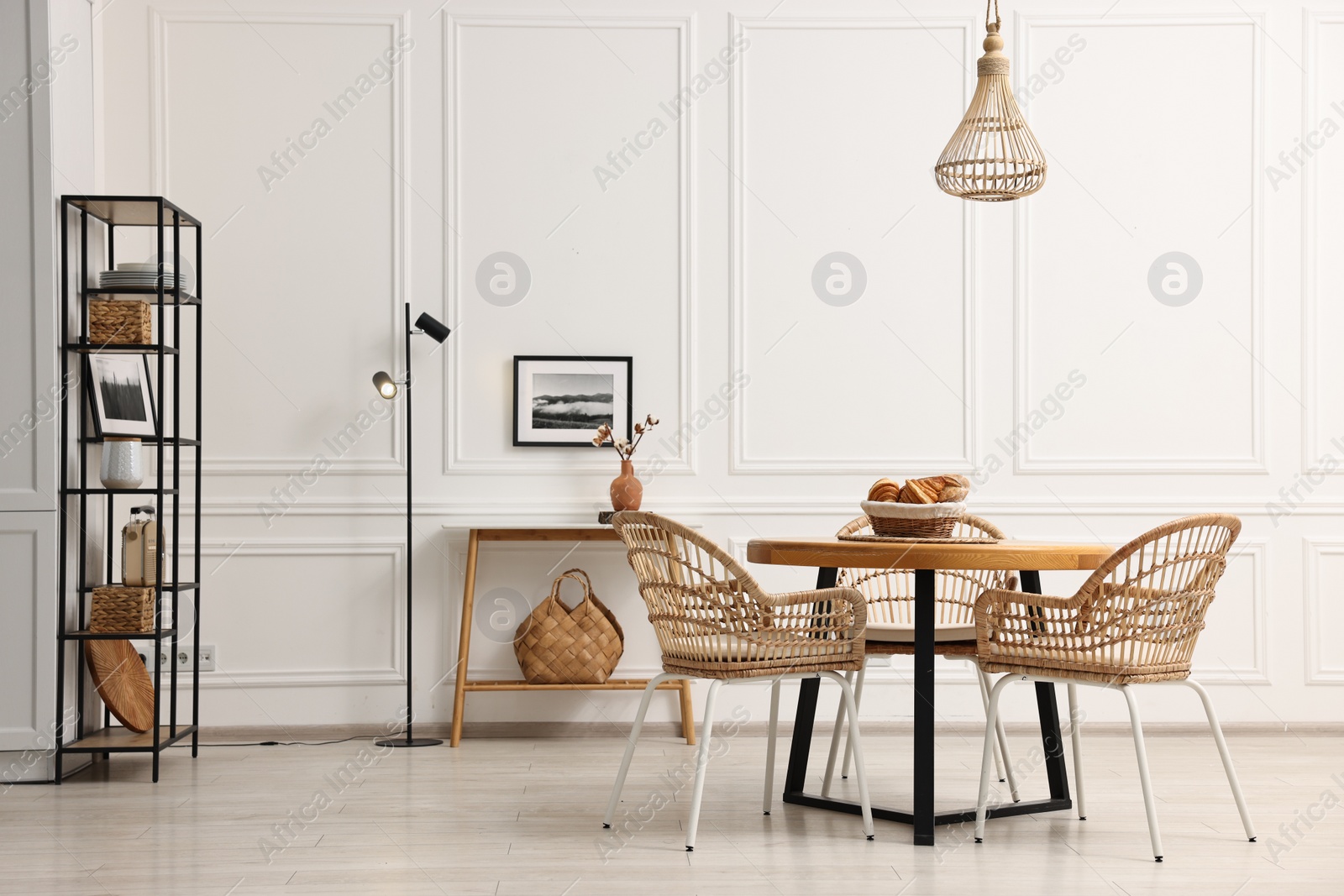 Photo of Dining room interior with wooden table and wicker chairs