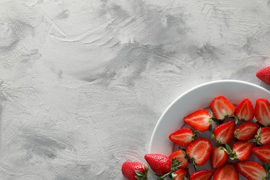 Food photography. Plate of delicious ripe strawberries on grey textured table, top view with space for text