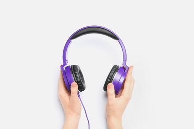 Photo of Woman holding stylish headphones on white background, closeup