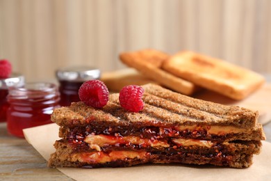 Image of Tasty sandwich with raspberry jam and peanut butter for breakfast on table