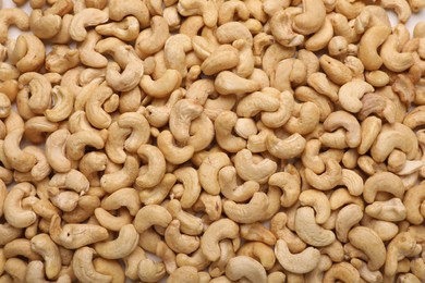 Photo of Many tasty cashew nuts as background, top view