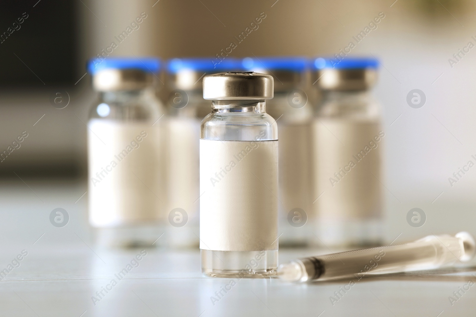 Image of Medication in vials and syringe on table, space for text