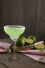 Photo of Delicious Margarita cocktail in glass on wooden table