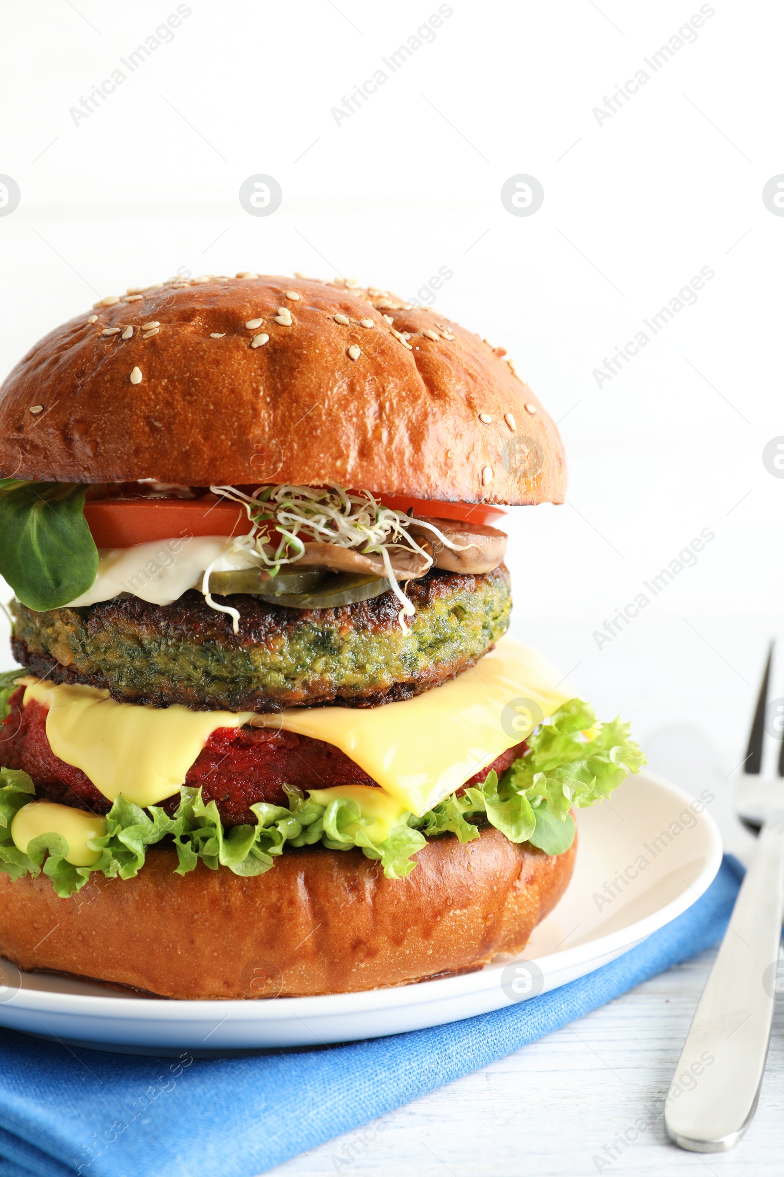 Photo of Vegan burger with beet and falafel patties served on white table