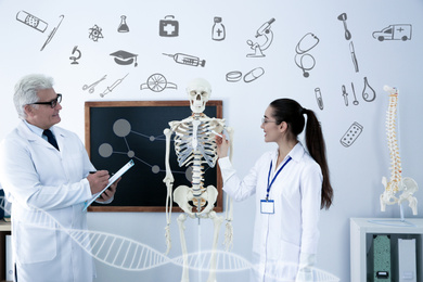Image of Medical student and professor studying human skeleton anatomy in classroom