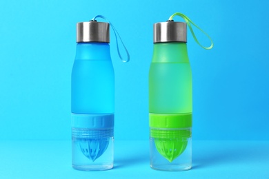 Sport bottles with water on color background