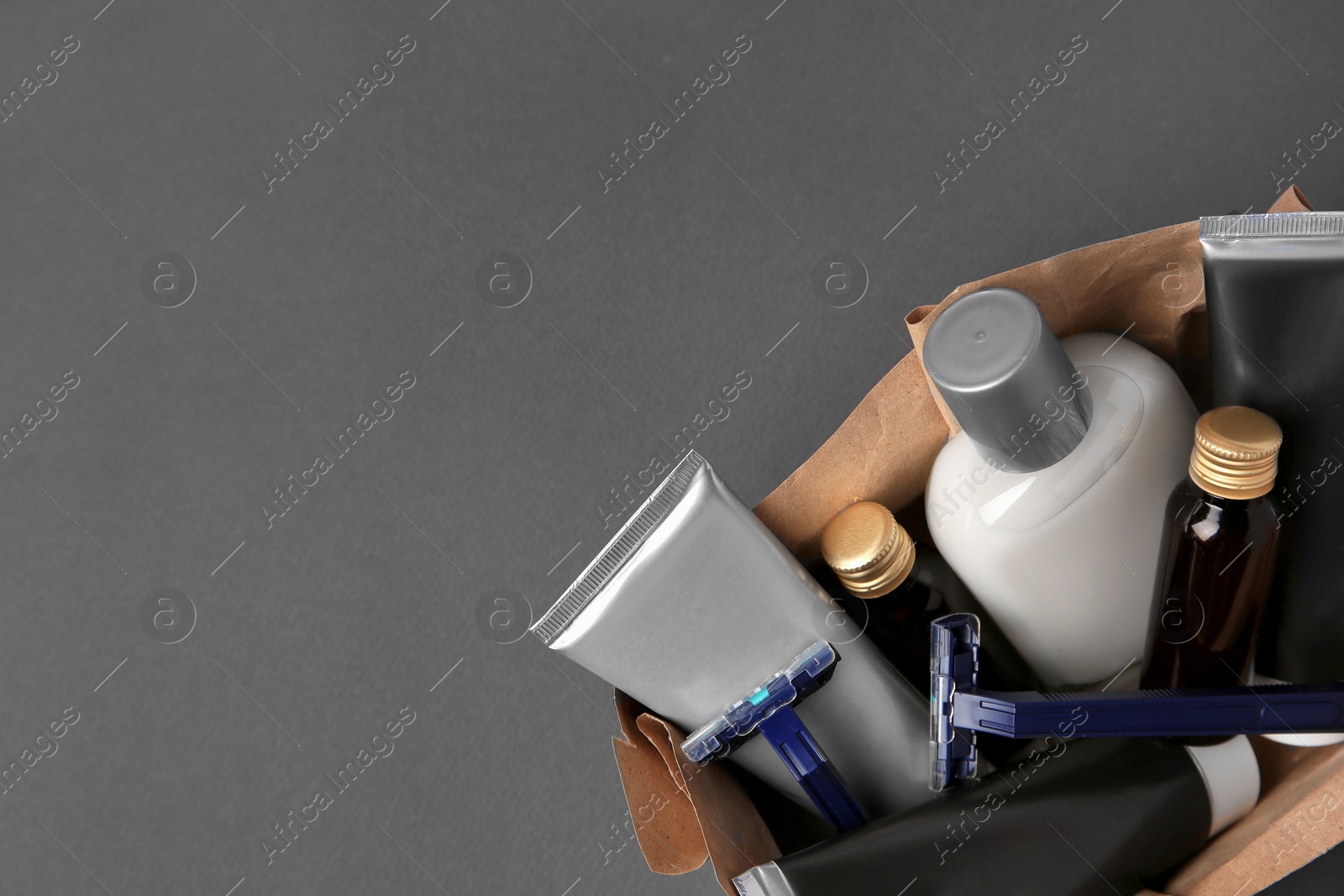 Photo of Box with different men's shaving accessories on dark grey background, top view. Space for text