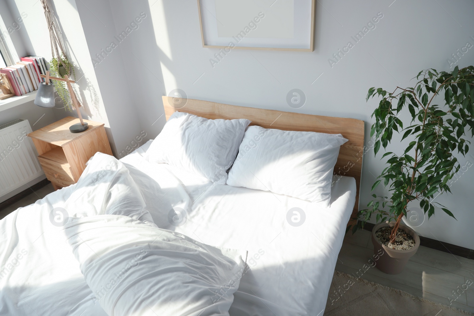 Photo of Large comfortable bed with soft pillows and blanket indoors