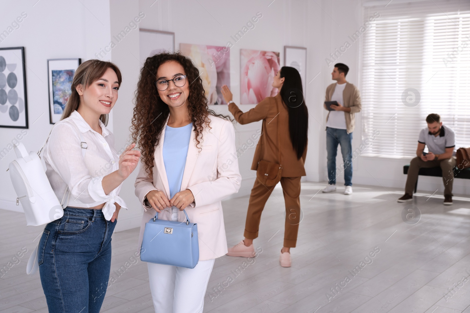 Photo of Young women at exhibition in art gallery