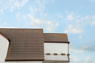 Photo of Beautiful house with brown roof against blue sky
