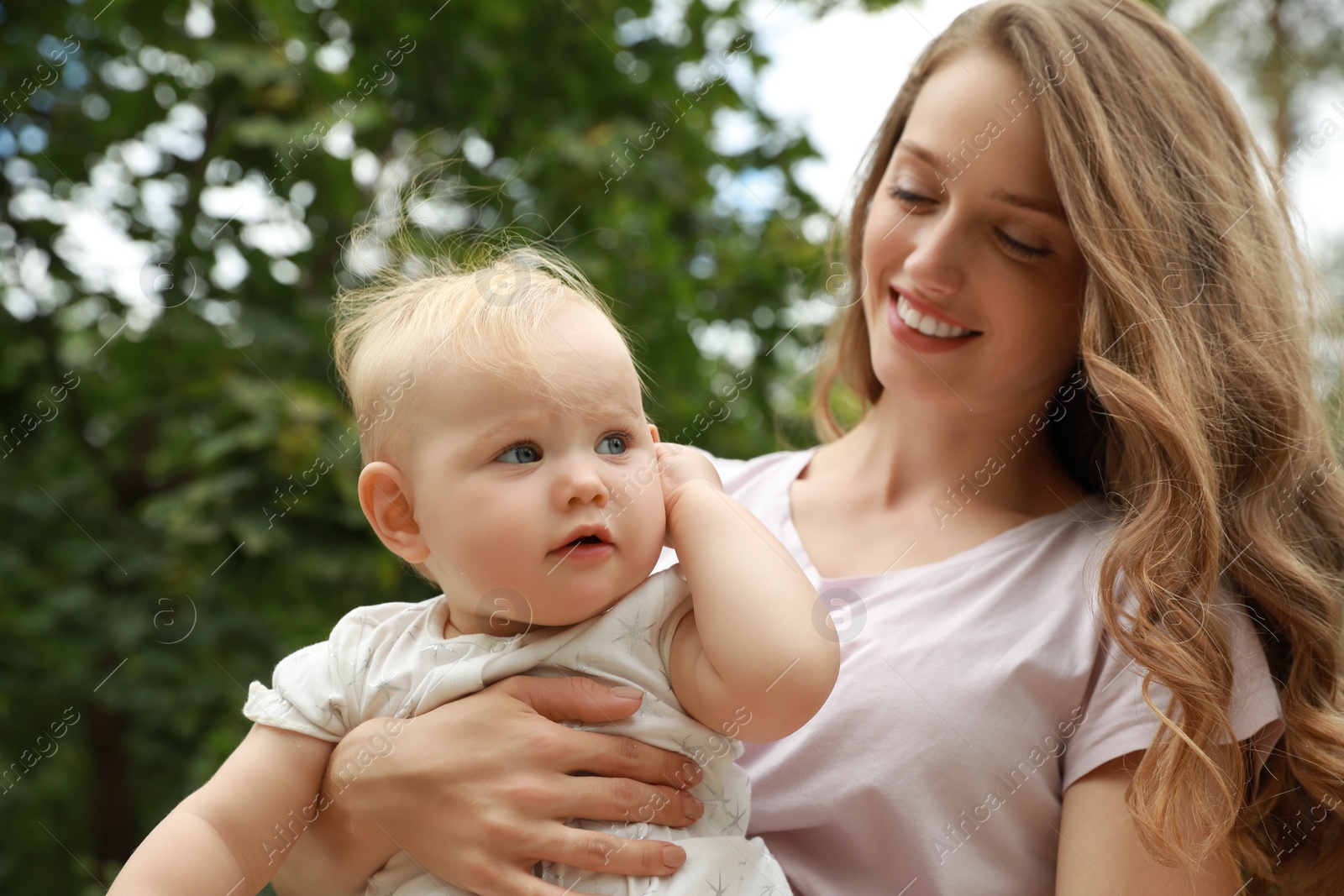 Photo of Mother with her cute baby spending time together outdoors