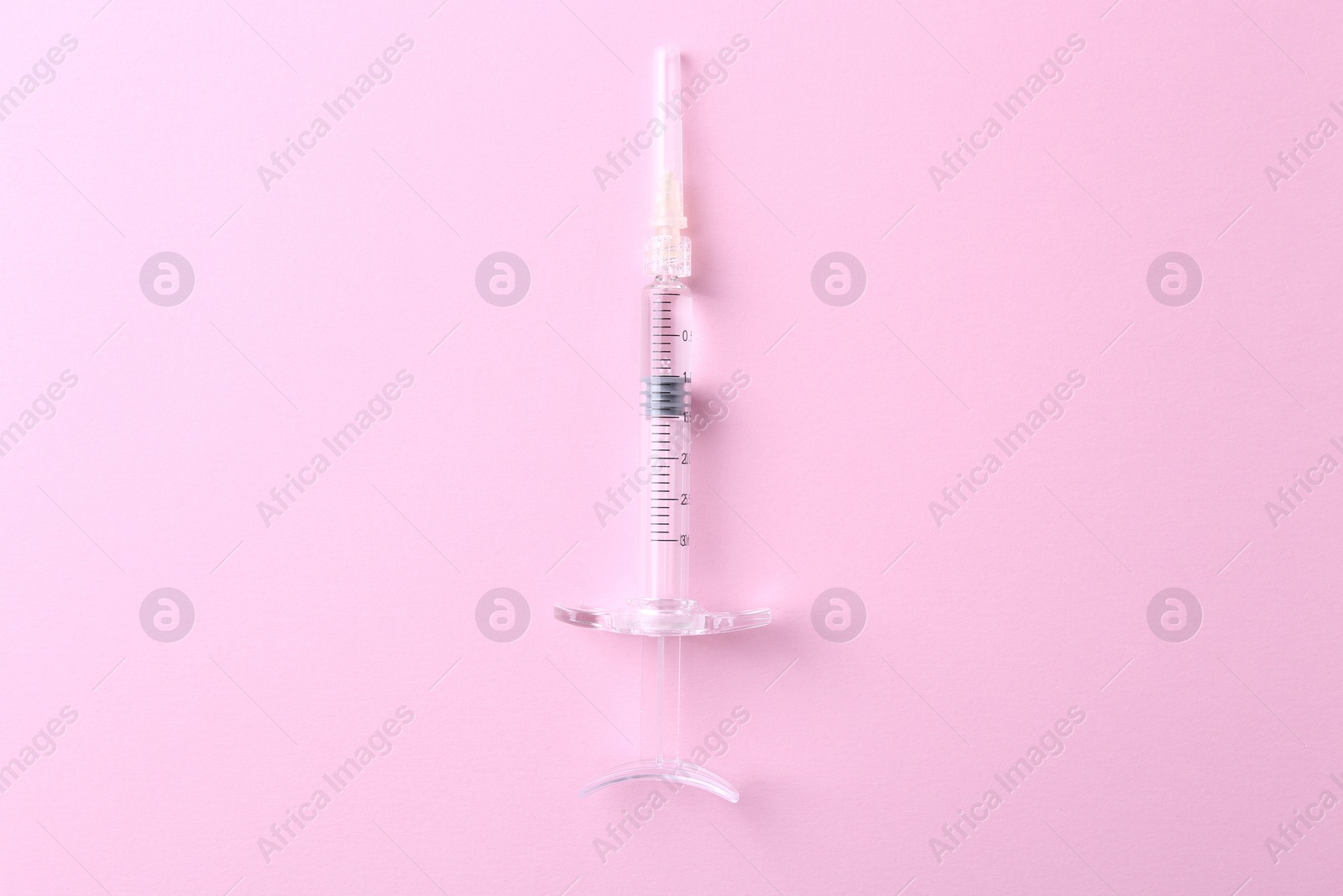 Photo of Cosmetology. Medical syringe on pink background, top view